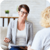 Female mental health professional smiling while helping a patient.